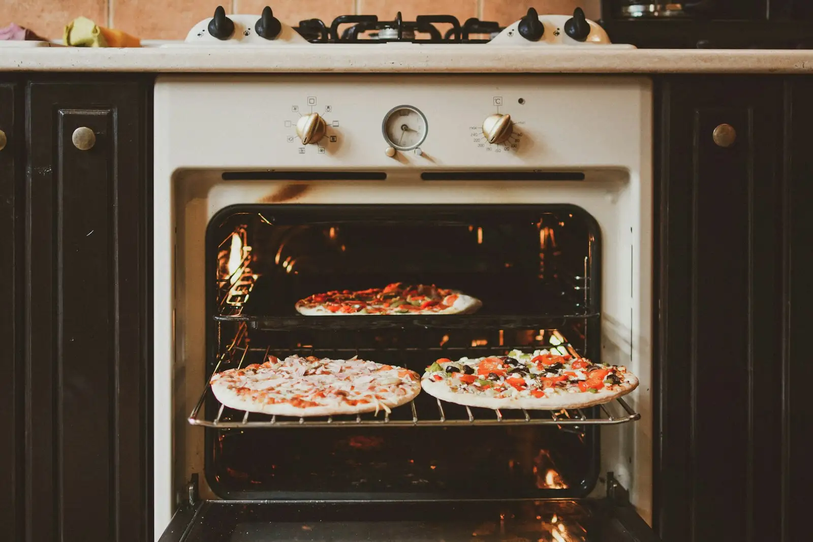 Homemade pizzas baking in a home oven, the setup where a preheated pizza stone gives the crispest crust