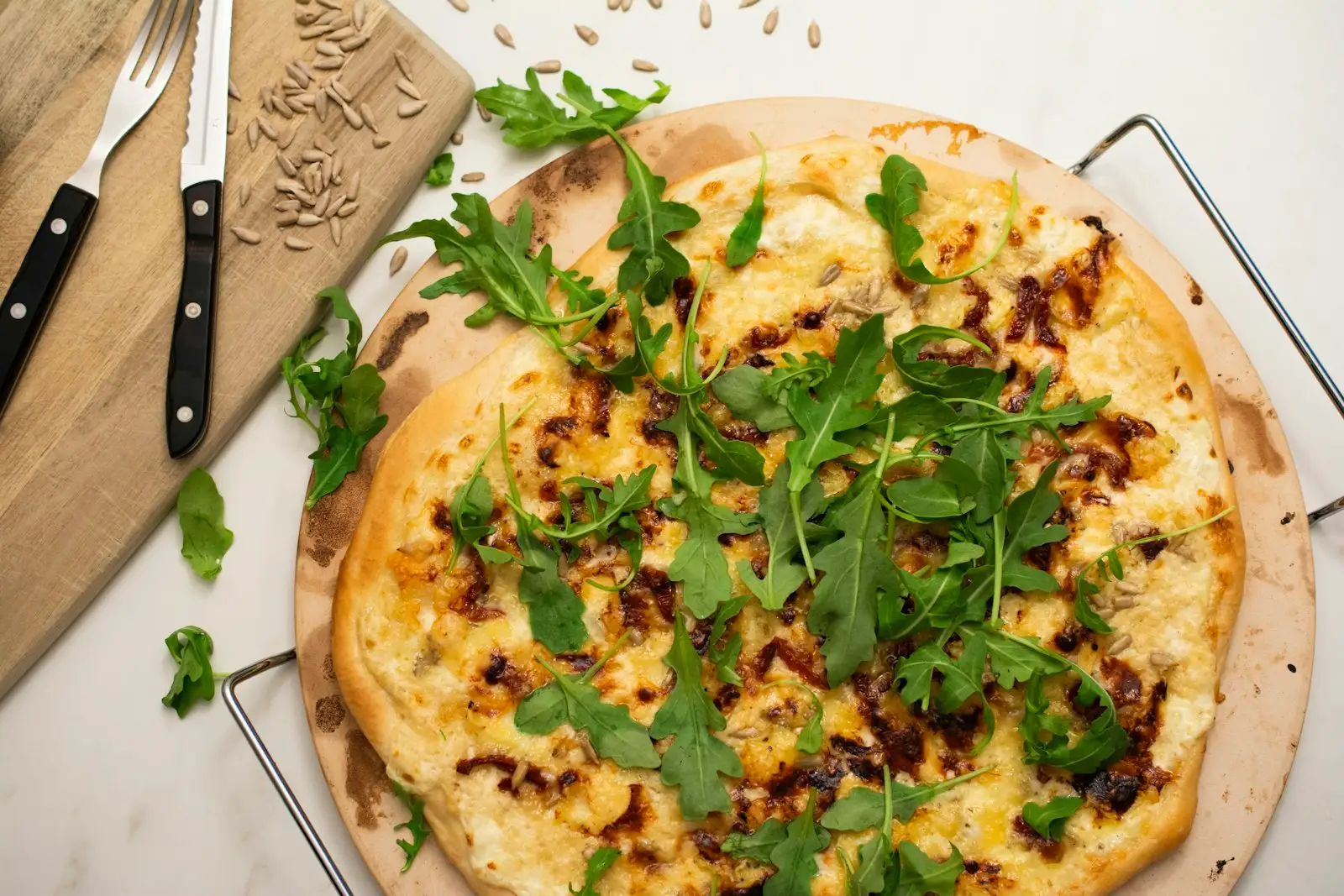 A baked pizza on a wooden cutting board, the result of a properly cared-for pizza stone