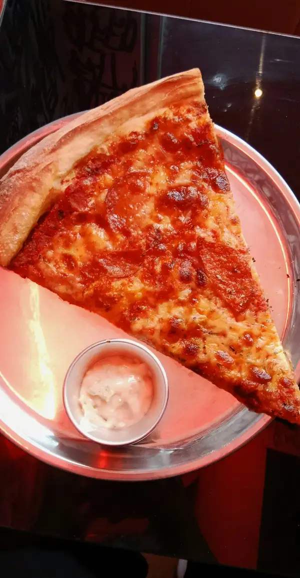 A foldable New York style pizza slice with a thin chewy crust on a plate
