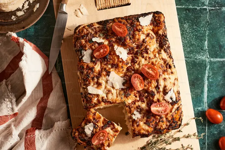 Rectangular pan pizza with deeply browned cheese top, the Detroit style format that demands Wisconsin brick cheese